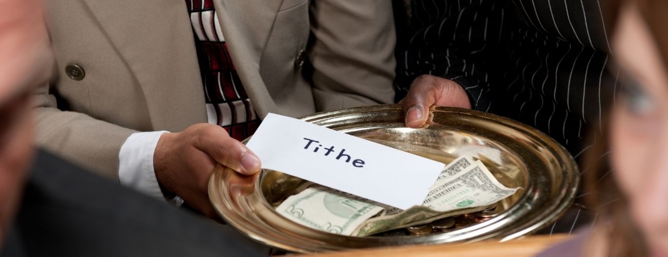 Man holding paper with Tithe written on it