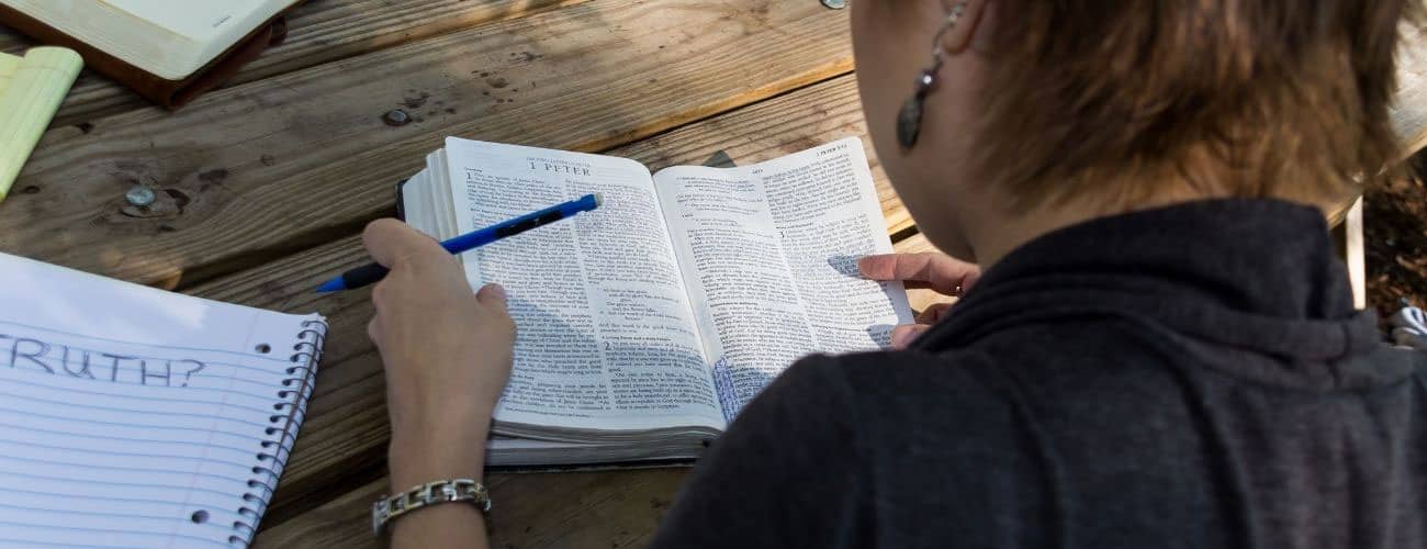 Female reading bible with Truth on piece of paper